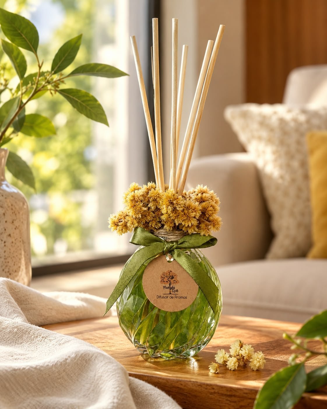 Difusor de aromas com arranjo de sempre-vivas e laço verde, em uma sala iluminada